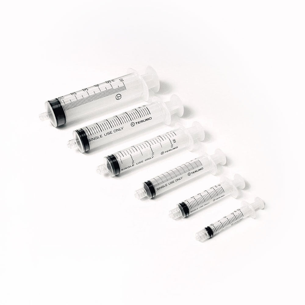 A row of six clear MedPharma USA syringes, made from medical-grade plastic, with precise measurements from 10cc to 12cc and a black plunger, is set against a plain white background to highlight their clarity and functionality.